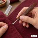 Tapered brown handle seam ripper removing a stitch