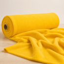 Yellow fleece fabric displayed on a roll with soft draped folds